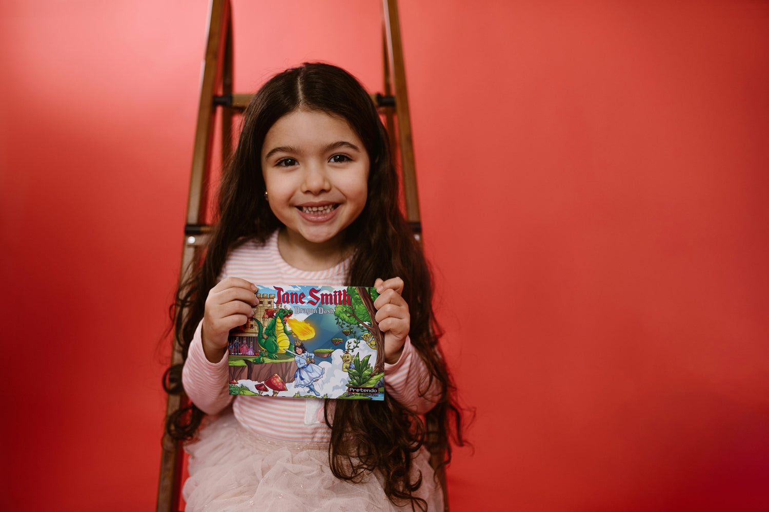 A little girl holding a personalized video game card from Pretendo Cards